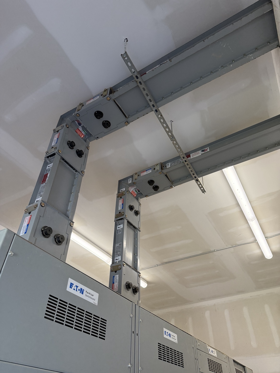 Overhead busway feeding electrical distribution equipment